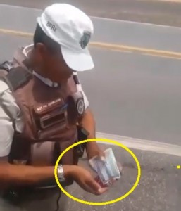 sargento da Polícia Rodoviária pega dinheiro em carteira de caminhoneiro
